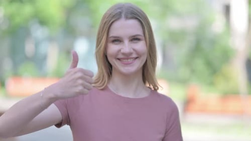 Young Woman Gives Thumbs Up in Urban Setting