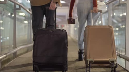 Close up of young couple passenger holding luggage in airport terminal.