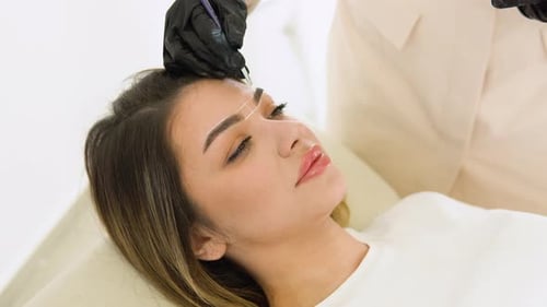 Markup with White Pencil on Eyebrows of Yong Woman While Permanent Make Up