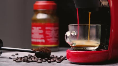 Hot coffee flows into a cup with an espresso machine, close-up.