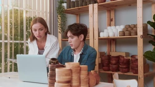 A young couple entrepreneur checking and packaging craft products selling