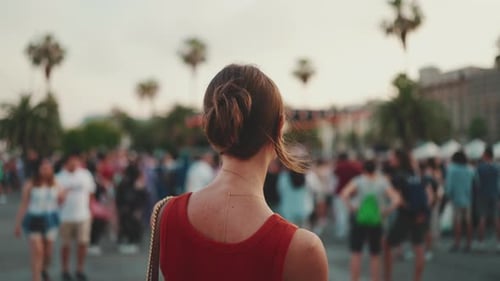 Close-up, girl stands on the square and looks around in the downtown