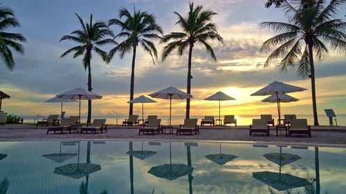 Umbrella and chair around swimming pool in resort hotel for leisure travel and vacation neary sea oc