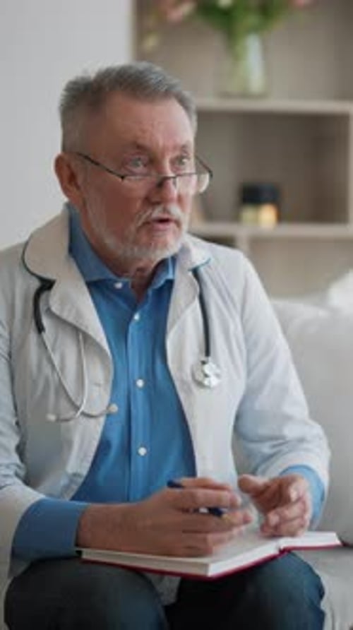 Male Doctor with Gray Hair Taking Notes