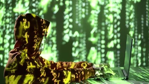 Anonymer Hacker im Kapuzenpulli mit Maske, Laptop und grüner Code-Projektion — 4K-Video zur Cyberkriminalität