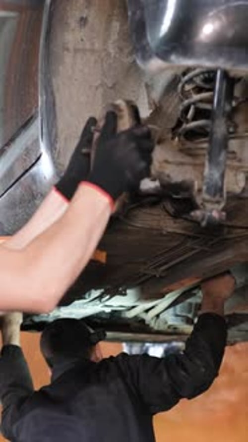 A Professional Car Mechanic Examines a Car at a Car Service Performing a Series of Tests