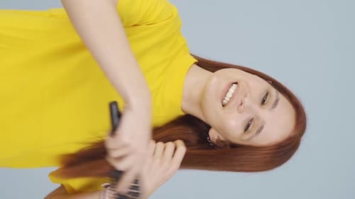 Vertical video of Woman combing her hair. Hair care.