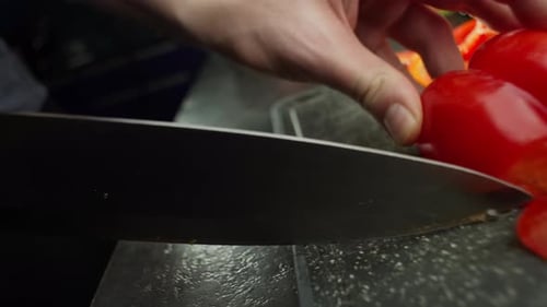 Close-up of Sharp Knife Slicing a Red Pepper