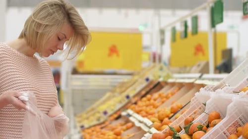 30s Women Selecting Fresh Fruit in Grocery Store Supermarket Sale Closeup