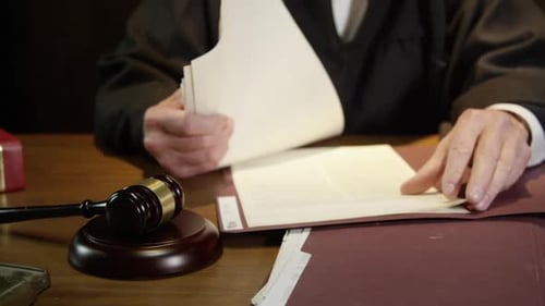 Judge wide angle looking through papers in court case HD