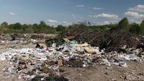 Landfill of Discarded Rubbish Under Blue Sky