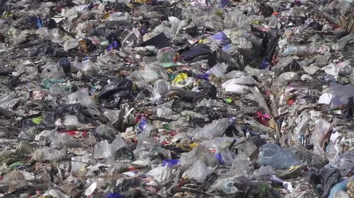 Zoomen Sie aus Plastikmüll auf einer Müllhalde heraus. Zeitlupe, Handgerät
.