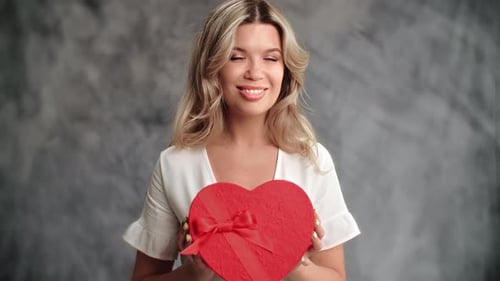 Portrait Beautiful Woman Posing Red Gift Box Heart Shape Celebrate Holiday Isolated on Gray Studio