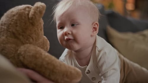 Anonymous Mother Playing with Baby Girl Touching Soft Toy Bear