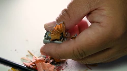 Footage of hands slowly sharpening a pencil and some coloured pencils with a Wedge Pencil Sharpener.