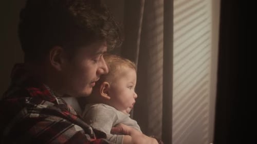 Father Holding Baby Near Window