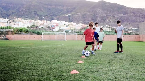 Sport soccer kids training slalom drill for agility practice - Football players run between cones