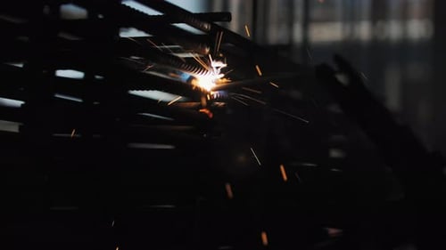 Welding Metal Bars with Sparks in Factory