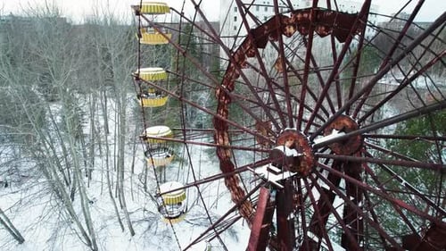 Rusty Ferris Wheel and winter Pripyat city in Chernobyl exclusion zone.