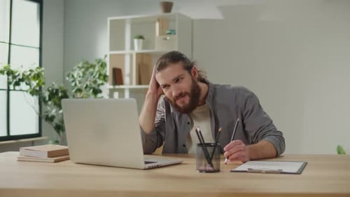 Tired Man Working on Laptop at Home