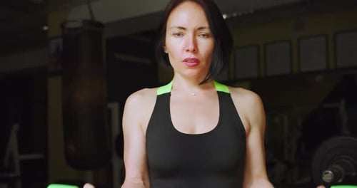 A Fit Middle Aged Caucasian Woman During Gym Workout Bicep Workout with Dumbbells