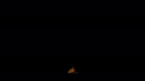 Ignite Collection: Tiny fire waves ooze from bottom center of a ground on dark background shot in 4k