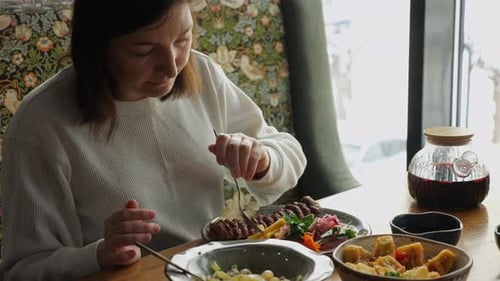 Woman Enjoying a Delicious Meal at a Restaurant