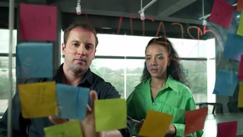 Two Adults Brainstorming Ideas Using Sticky Notes