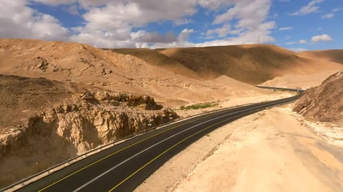 Empty Desert highway mountain road with Blue cloudy sky
