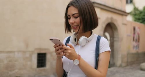 Smiling Woman Using Smartphone in an Urban Setting