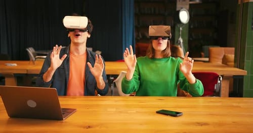 Young Couple Interacting with Augmented Reality in Vr Goggles in Modern Office