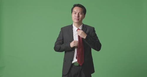Asian Business Man In Jacket And White Classic Shirt Wearing Red Necktie On Green Screen Background