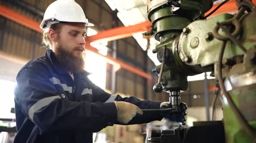 Fabrikarbeiter richtet CNC-Drehmaschine ein