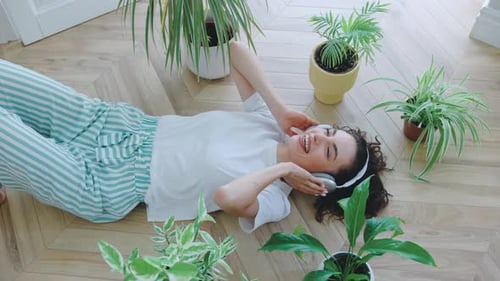 Woman Relaxing on Floor Listening to Music With Headphones