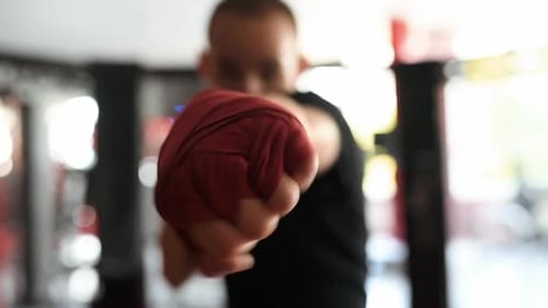 Focused video of man's fists in red boxing bandages doing punches