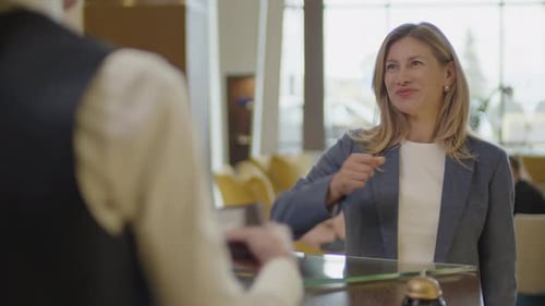 Female Guest Giving Passport to Receptionist during Hotel Check-In