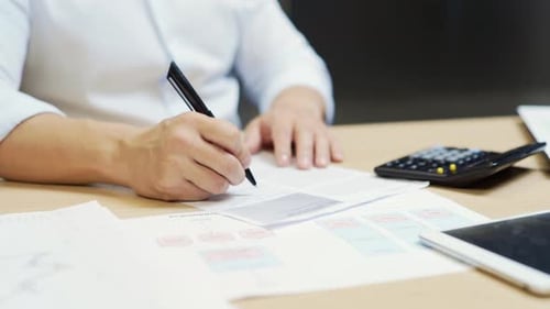 hands close up of financial analyst accountant or bookkeeper counting report on calculator