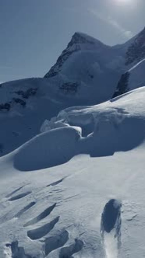 Eine wunderschöne und verschneite Berglandschaft voller markanter Fußabdrücke im Schnee