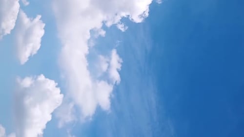 Nahtlose Schleife flauschiger Wolken am blauen Himmel in einer Sommeraufnahme an einem klaren Tag. Video mit Schleifendem Hintergrund