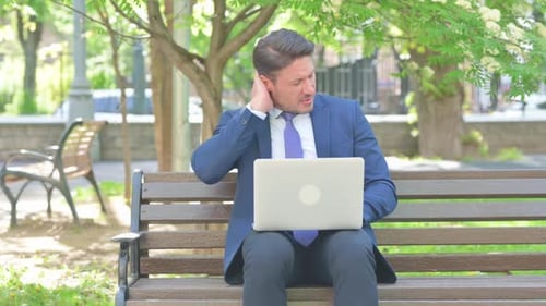 Man in Suit Working on Laptop in Park