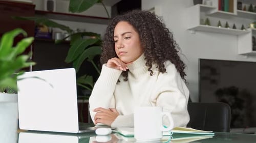 Woman Celebrates Success with Laptop at Home