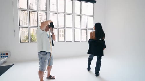 Photographer Taking Pictures of Model in White Studio