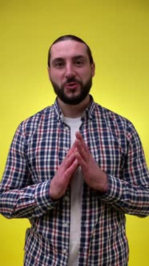 Adult Man Talking and Gesturing on Yellow Background