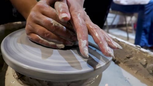 overhead close view of an African American hands spinning clay very sporadically