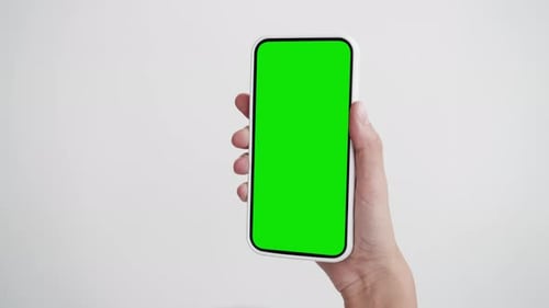 Point of view woman uses phone with green screen tapping touch mock-up indoors