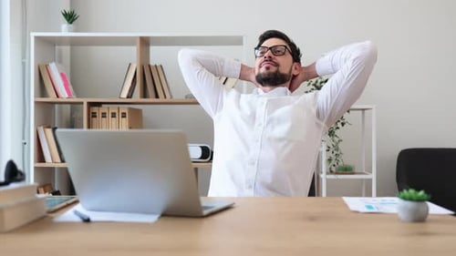 Man Taking a Break at Office Workstation Enjoying Relaxation