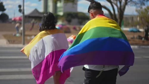 Couple Walk With Pride Flags in the City