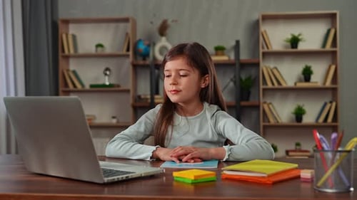 Young Child Girl Studying at Home Small Girl Sits at Desk and Attends School Class Online on Laptop