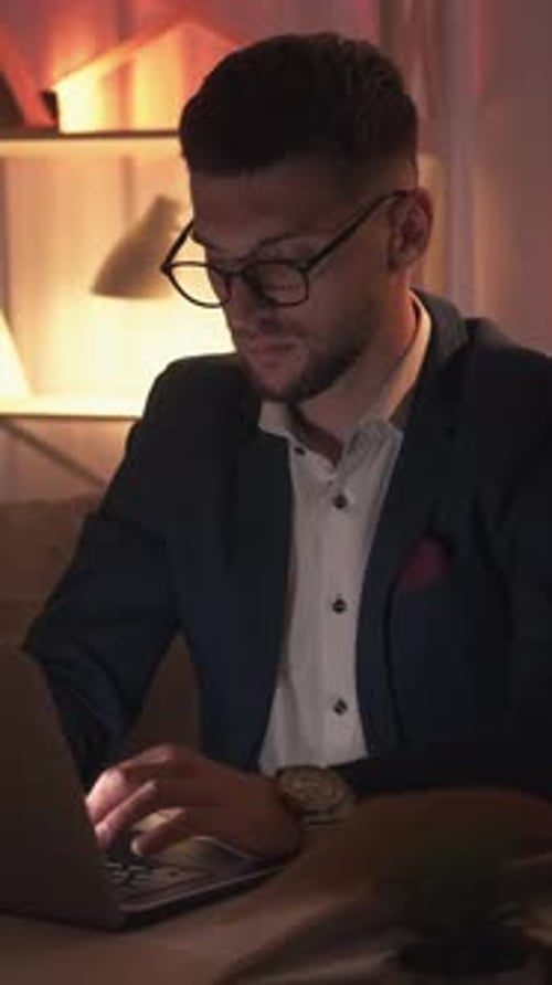 Young Adult Works On Laptop at Night