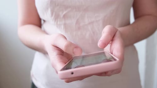 Woman Using Pink Mobile Phone Touch Screen
